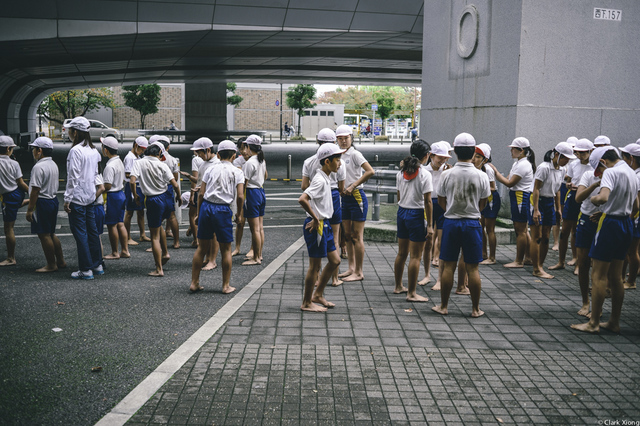 参加完集体操的小学生,个个赤脚等待着再次入场