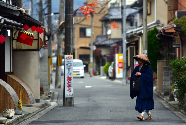 见到远处一位和尚模样的人在街道两边来回踱步,并挨家挨户在门口站立