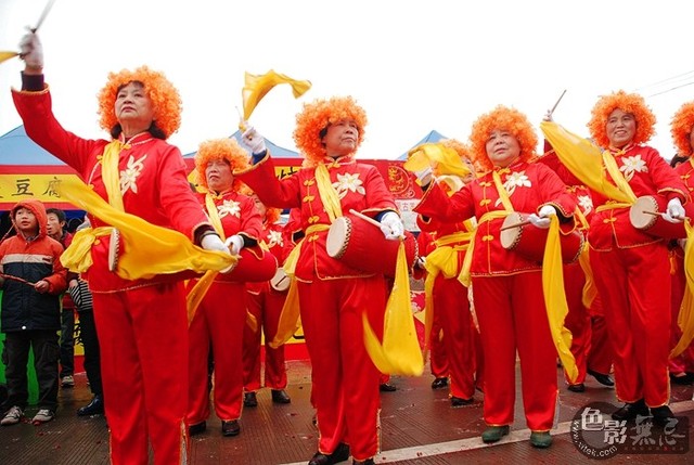 时尚老年腰鼓队       在广西柳州市西来寺春节庙会上,戴橘黄色假发的